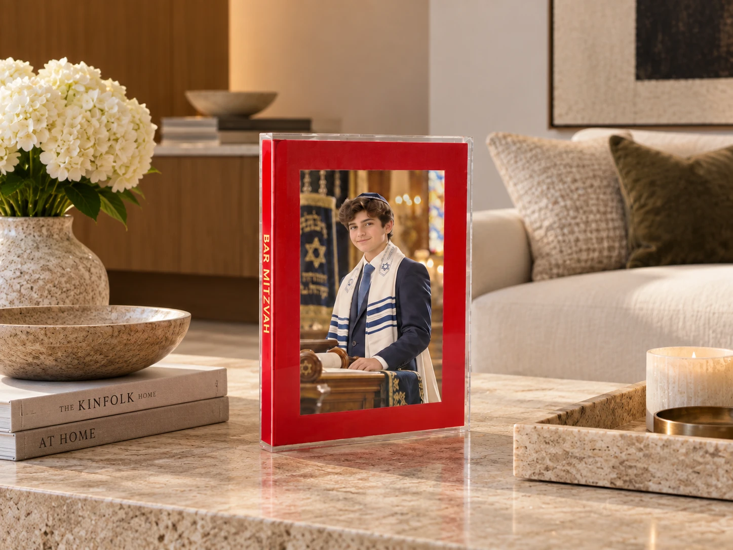 The Art Book by KONPOLI, a bar mitzvah album with a photographic cover, on a living room table